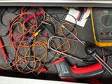 a bunch of wires and a multimeter in a drawer