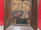 painting of the virgin and child in a wooden frame on a red wall