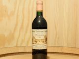 une bouteille de vin posée sur un tonneau en bois