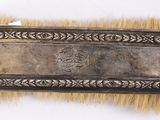 an old silver plate with a brush on top of it