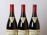 trois bouteilles de vin posées sur une table en bois