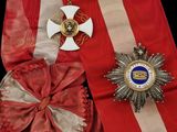 un ruban rouge orné d'une croix et d'une médaille