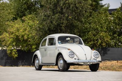 une Coccinelle VW blanche garée sur le bord de la route