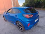 the rear end of a blue car parked in a parking lot