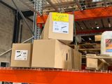 Les cartons sont empilés sur une étagère dans un entrepôt, sur laquelle est accrochée une pancarte