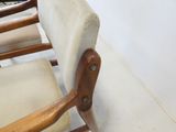 a chair with a wooden arm rest and a beige seat