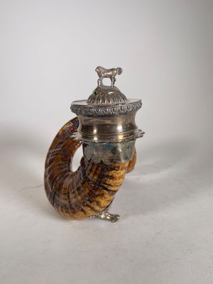 une image représentant une théière en argent en forme de corne, surmontée d'un oiseau