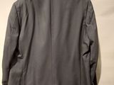 the back of a gray jacket hanging on a hanger