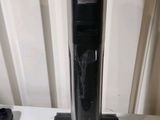a black and silver vacuum on a table next to a remote control