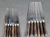 six knives are lined up on top of each other on a table