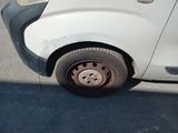 a small white car with a flat tire on the street