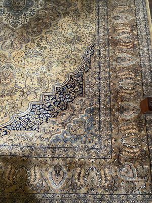 a rug on the floor with a chair in the background