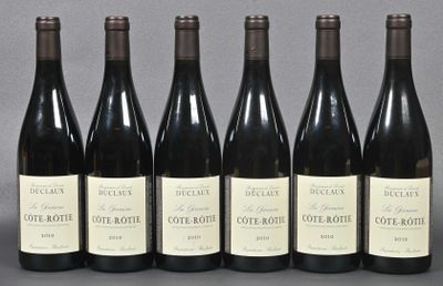 six bottles of wine are lined up in a row on a table