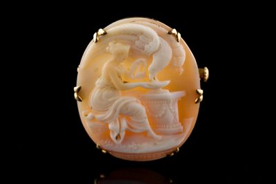une coquille sculptée de forme ovale représentant une femme assise sur une table