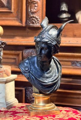 une statue représentant une femme portant un casque, posée sur une table