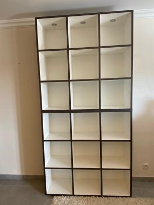 a tall bookcase with many shelves in the room