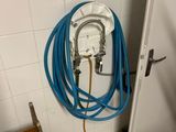 un tuyau bleu fixé au mur d'une salle de bains