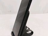 a close up of a cell phone on a stand on a white surface