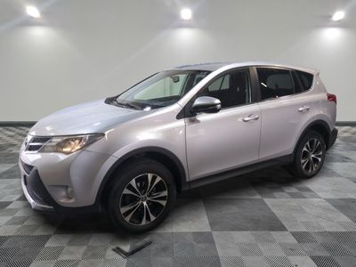 Une Toyota RAV argentée est garée dans une pièce au sol à carreaux.