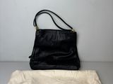 un sac à main en cuir noir avec une pochette à cordon posée sur une table