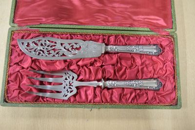 un service d'argenterie dans un coffret rouge posé sur une table