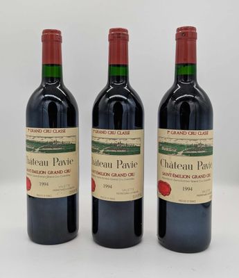 trois bouteilles de vin rouge posées côte à côte sur une table