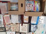 a box full of stamps sitting on a table in front of a pile of other stamps