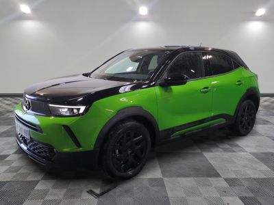 a green suv is parked in a room with a checkered floor