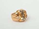 a close up of a gold ring with diamonds on a white surface