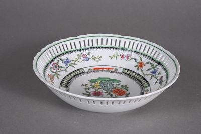 a white bowl with green and red designs on it