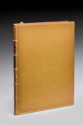 un vieux livre avec une couverture dorée sur fond noir
