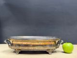 an old metal bowl sitting on top of a wooden table next to an apple