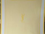 un foulard carré jaune et blanc orné d'un monogramme