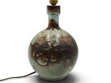 un vase marron et vert sur lequel est posée une lampe