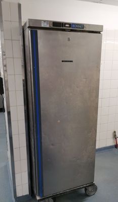 a silver refrigerator in the middle of a blue floor
