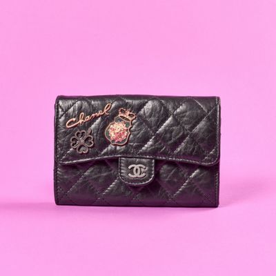 un gros plan d'un sac à main noir sur fond rose