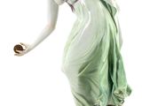 an antique figurine of a woman holding an apple in her hand