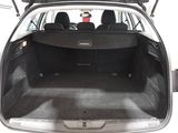 the back of a white car with its trunk open and the back seats folded down