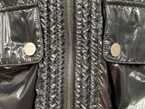the back of a shiny jacket with a zipper on it