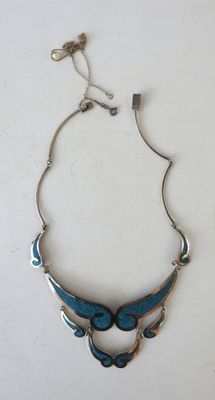 a close up of a necklace on a white surface