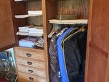 an image of a closet with a lot of clothes in it