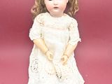 a small doll that is sitting on a pink surface