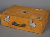 an old yellow suitcase with a handle on a gray background