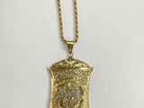 a gold plated necklace with an ornate design on a chain