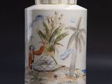 a white vase with a painting on it sitting on a table