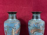 deux vases posés sur une table en bois, avec un mur rouge en arrière-plan