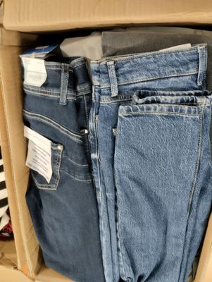 une boîte en carton remplie de jeans et une paire de chaussures