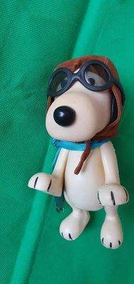 un jouet représentant un chien portant une casquette de pilote et des lunettes de protection