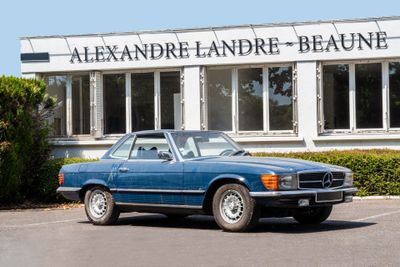 a blue car parked in front of a building