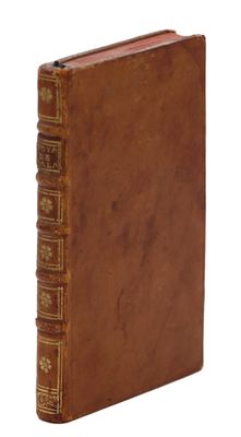 un vieux livre à la couverture brune posé sur une surface blanche